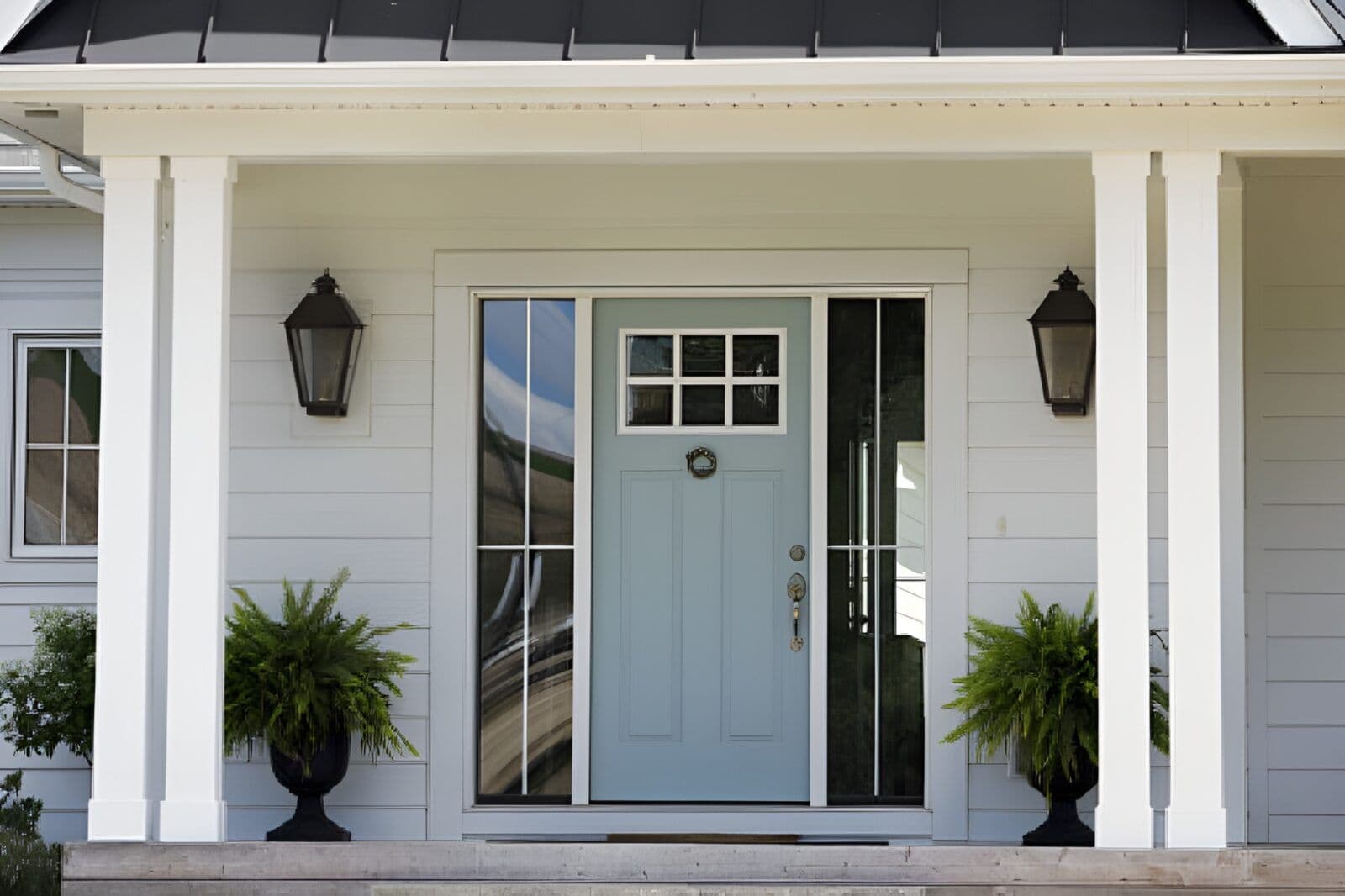 A pale blue ProVia entry door on a white house with a porch.