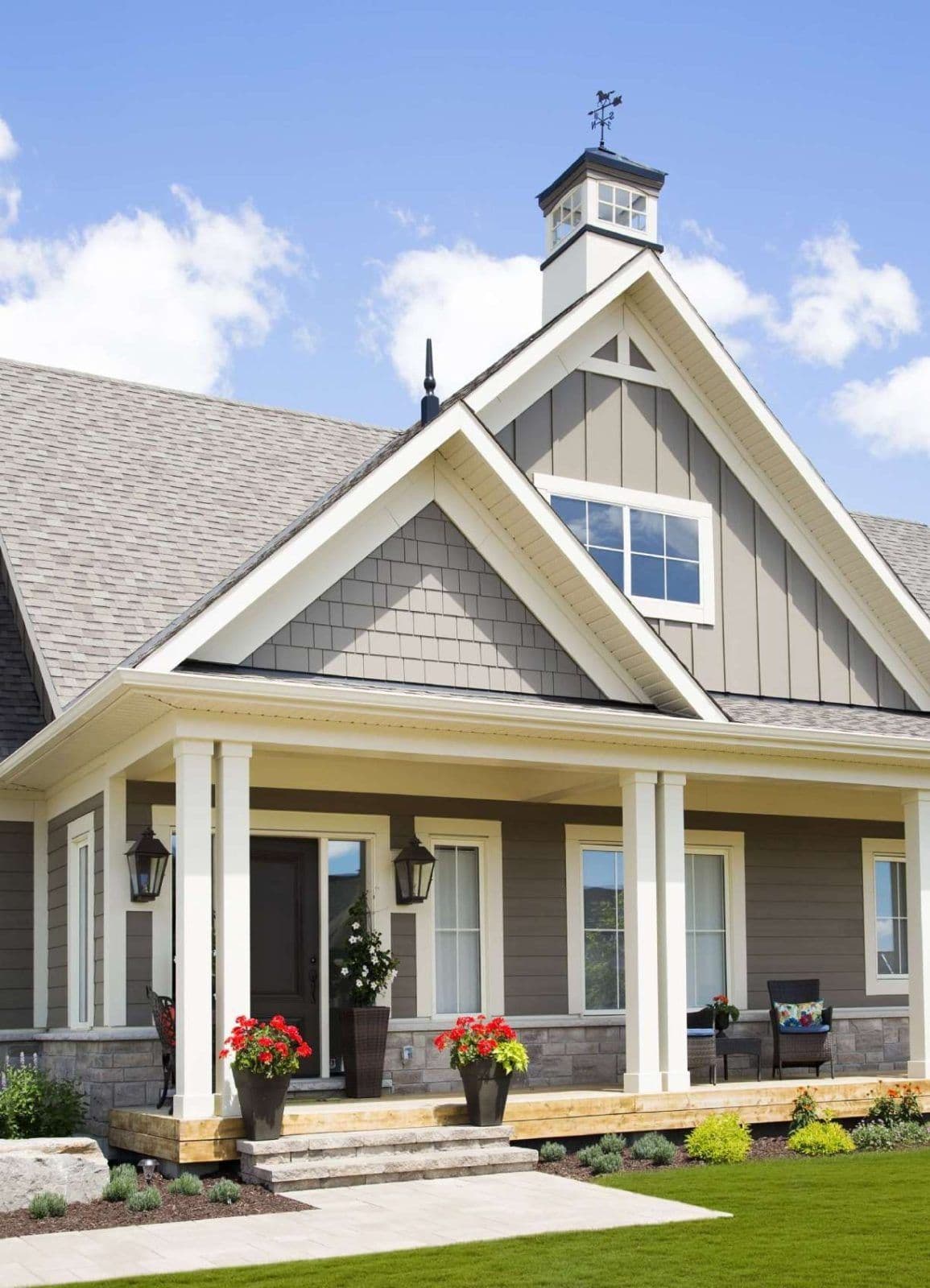 A gray and white house with Andersen replacement windows.