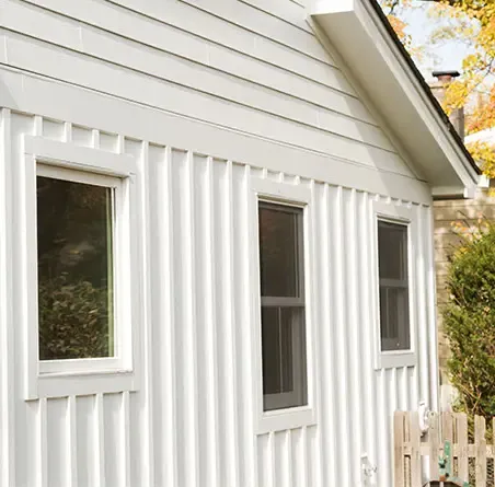 A white house with mixed vertical and horizontal James Hardie siding.