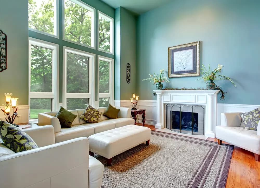 Two floors of Picture Windows in a green living room with white trim.