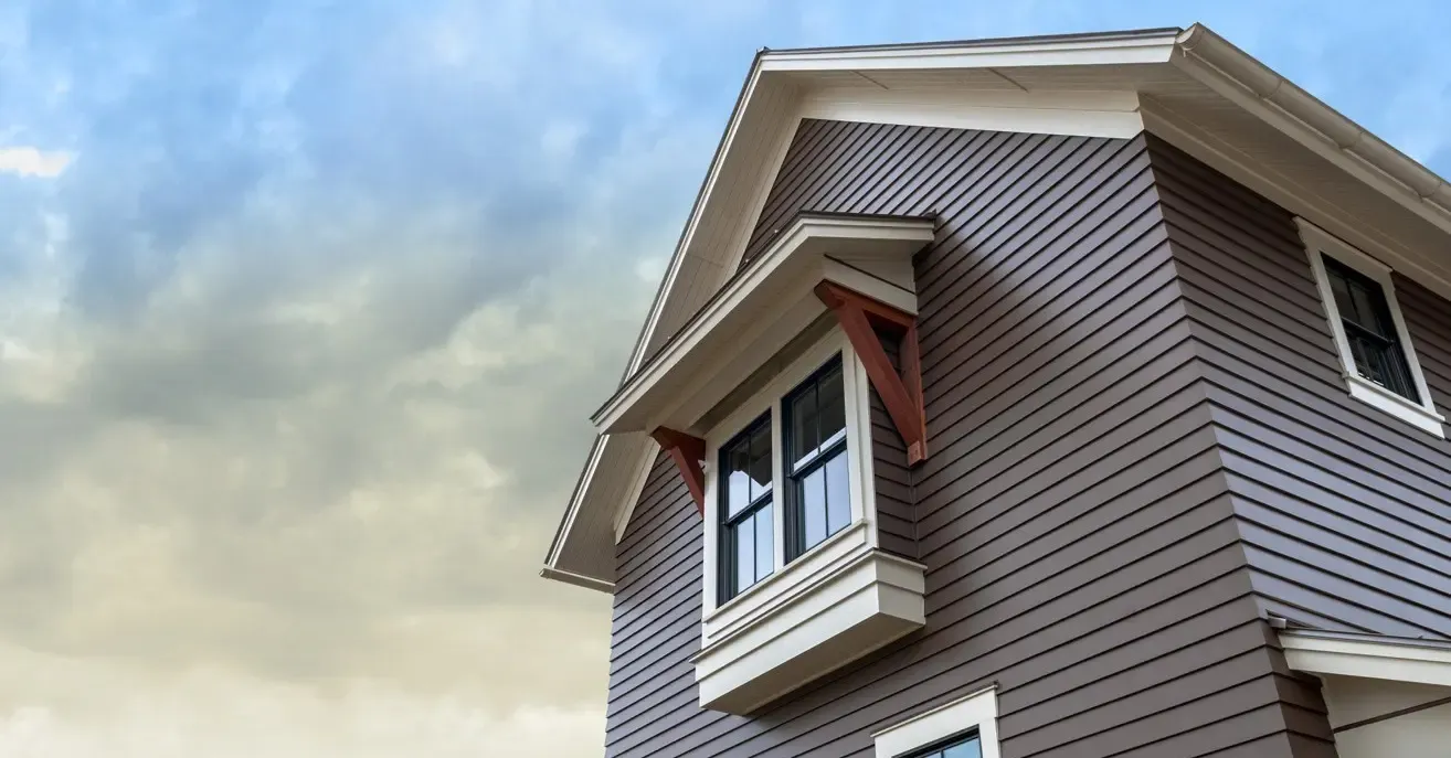 An upward-looking view of a gray house with James Hardie siding.