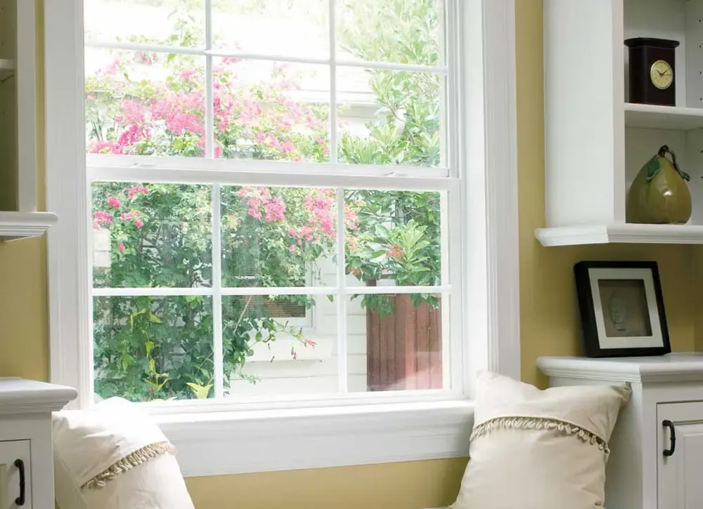 A single-hung window in a yellow room with white trim.